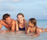 Family Lying In Sea On Tropical Beach Holiday