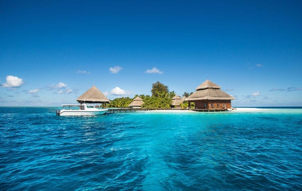 Small tropical island with Beach Villas and speed boat