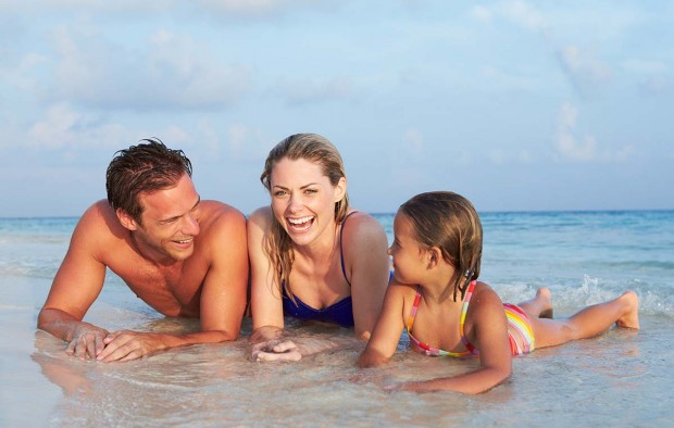 Family Lying In Sea On Tropical Beach Holiday