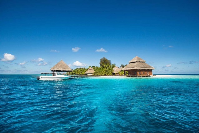 Small tropical island with Beach Villas and speed boat